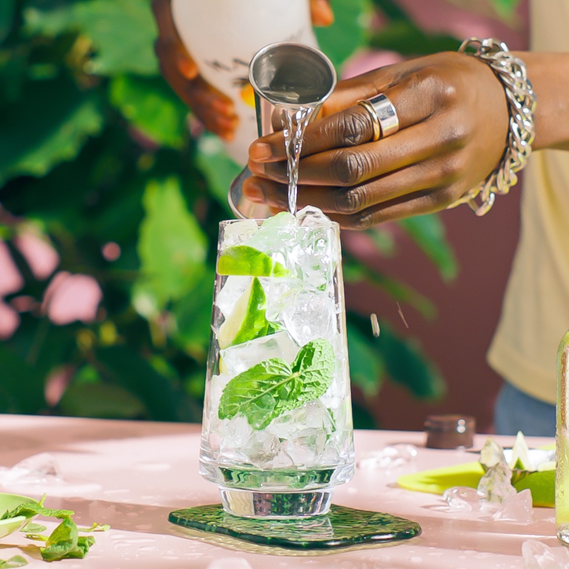 Malibu Mojito on a table in a tropical setting with Malibu rum being poured in the glass - step 4