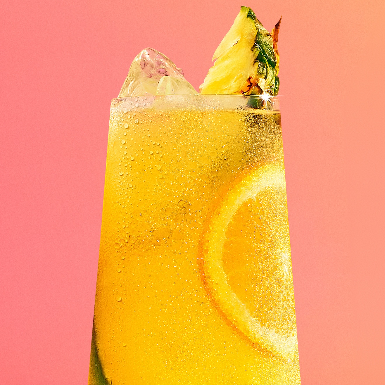 Malibu and pineapple cocktail on a coral background